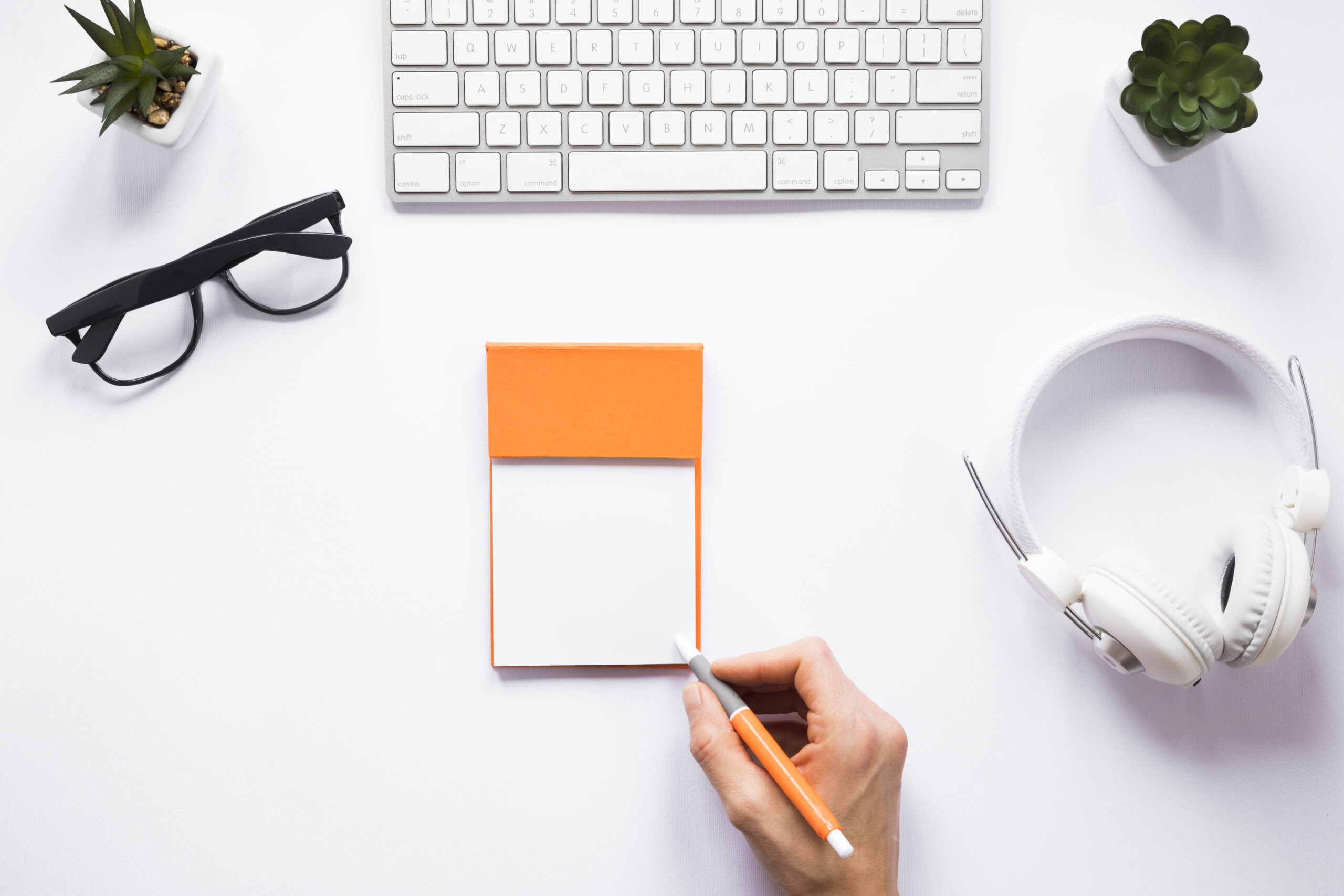 person-writing-sticky-notes-with-pen-white-workspace